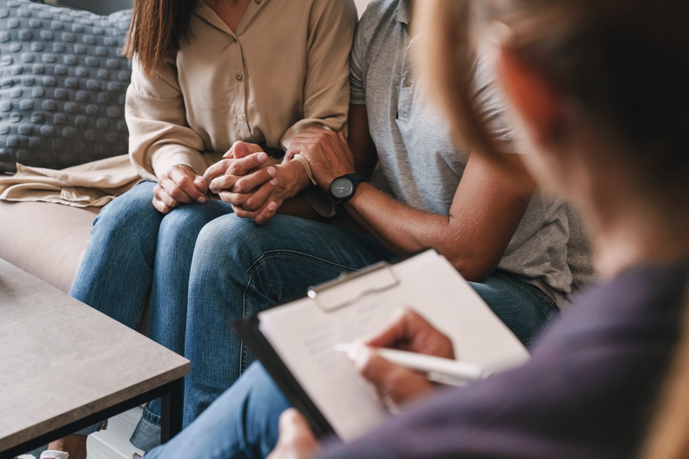 Cropped photo of casual nice couple man and woman having conversation with psychologist on therapy session in room